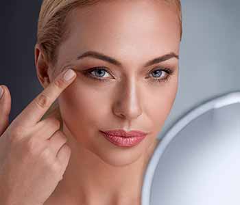 Image of a Middle age woman lokking skin on her face
